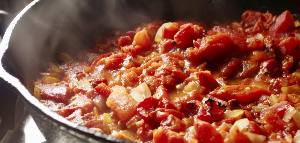 tomatoes and peppers cooking in pan