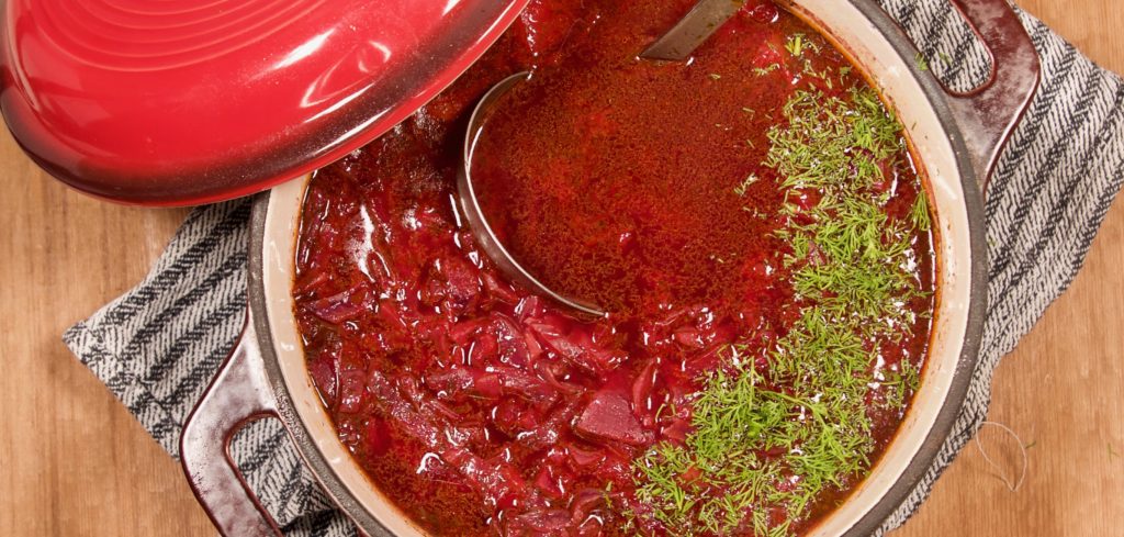 Borscht ingredients cooking together in a cast iron pot