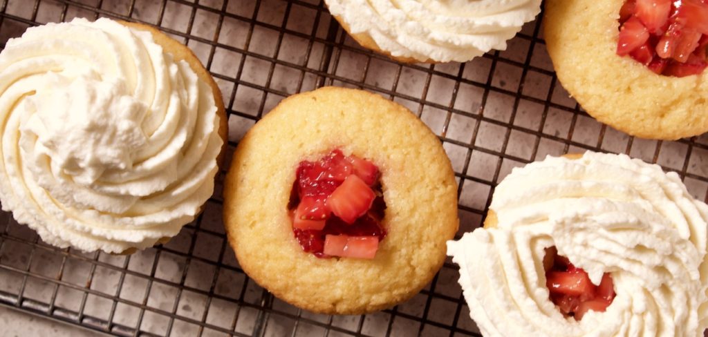 Strawberry Shortcake Cupcakes getting filled with Strawberries and Whip Cream