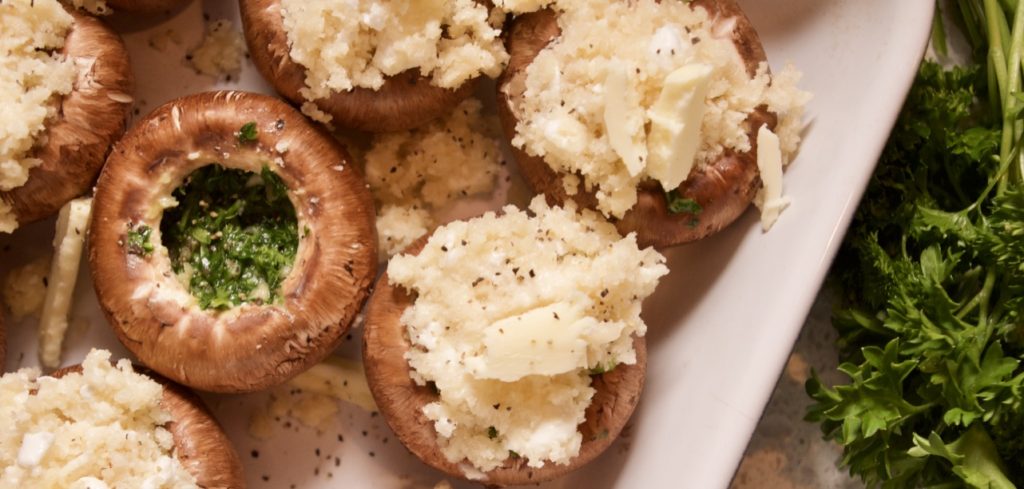 Chimichurri stuffed mushrooms with cheese topping in a baking tray