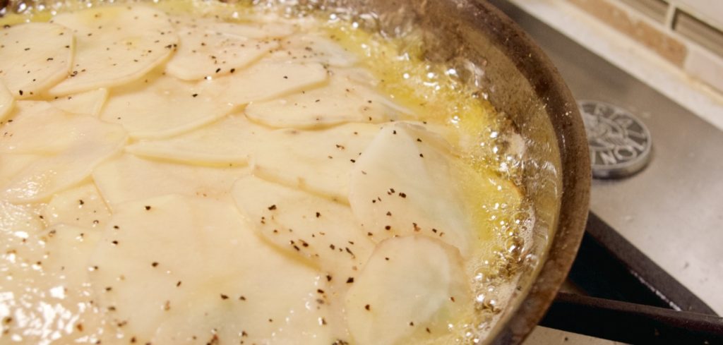 Anna Potato on stovetop, butter bubbling