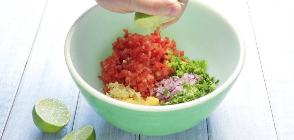 Squeezing lime over Salsa ingredients